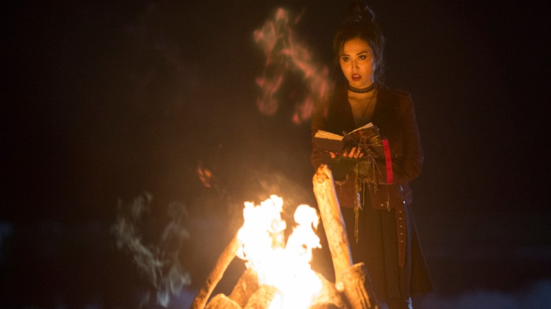 nico stands in front of a fire in runaways