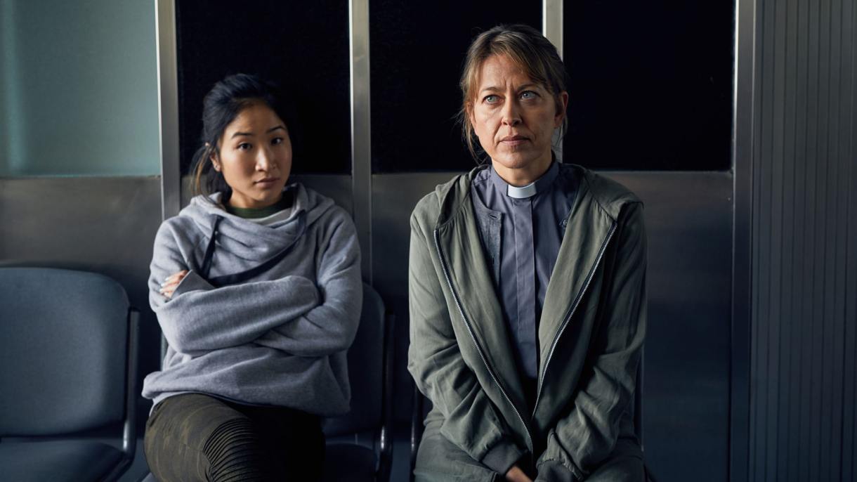 Nicola Walker in "Collateral" sitting on a chair in her vicar outfit