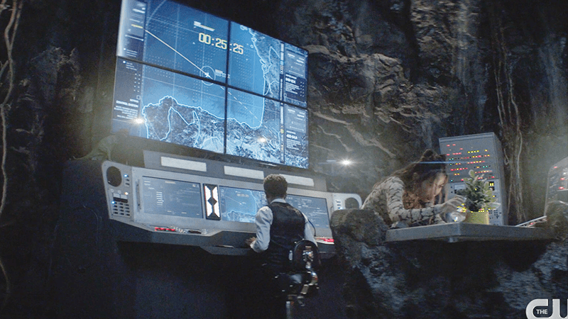 Luke at computer screens and Mary tending to the plant