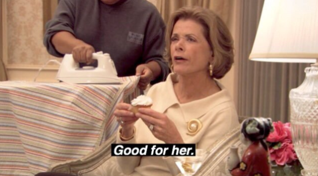 Jessica Walter, dressed as the mother in "Arrested Development" in a white suit, says her iconic line "Good for Her" while holding a cocktail.