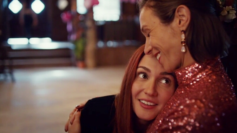 Nicole Haught leans on Waverly Earp's chest looking up at her with puppy dog eyes, Waverly laughs and squeezes her girlfirend close.