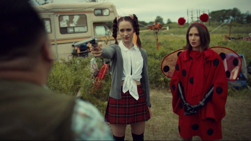 Wynonna holds up Peacemaker with Waverly looking stern by her side. Both in silly Halloween costumes.