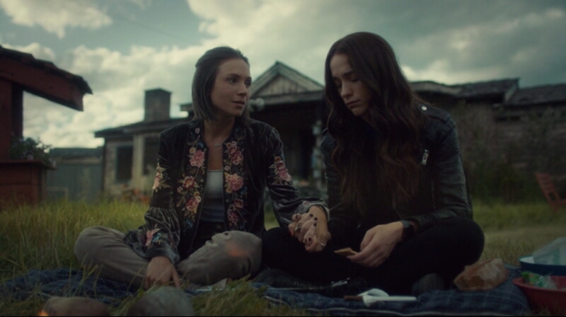 Waverly holds her sister's hand as she looks at her with love, Wynonna smiles softly and a bit sadly down at their clasped hands.