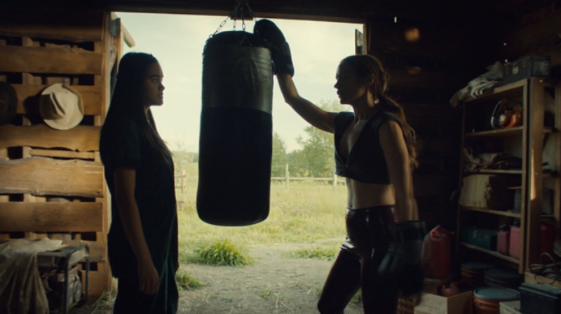 Rachel and Wynonna chat with a punching bag between them.