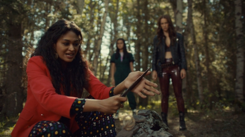 Cleo slices her palm open while Wynonna and Rachel watch.