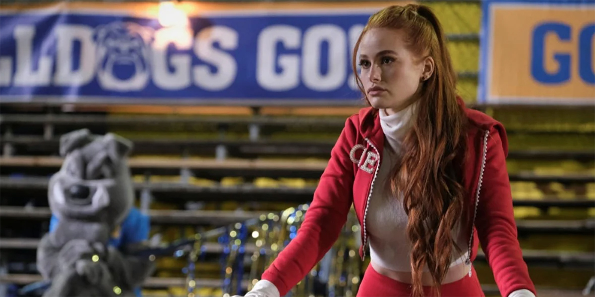 Cheryl Blossom stands on the sidelines of a Riverdale football game in her cheerleading coaching gear.