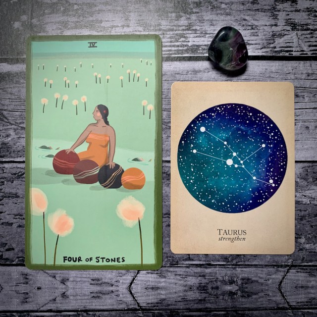 A photo of the tarot card for Four of Stones and the astrological card representing Taurus, along with a small crystal