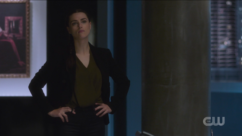 Lena stands with her hands on her hips.