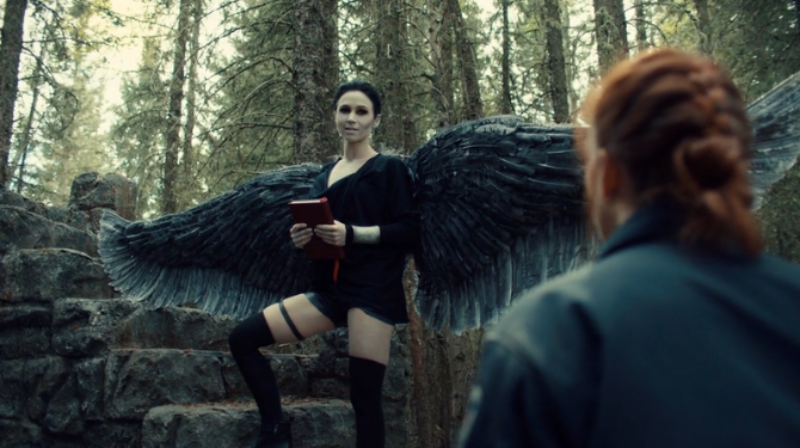 Dark Angel Waverly stands with one leg up on the stairs holding a book like someone read my dream journals.