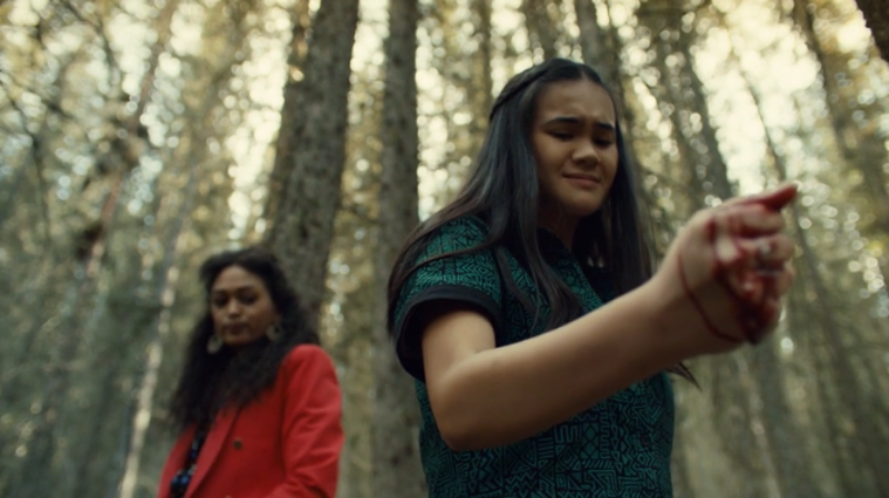 Rachel bleeds on a rock while Cleo watches menacingly in the background.