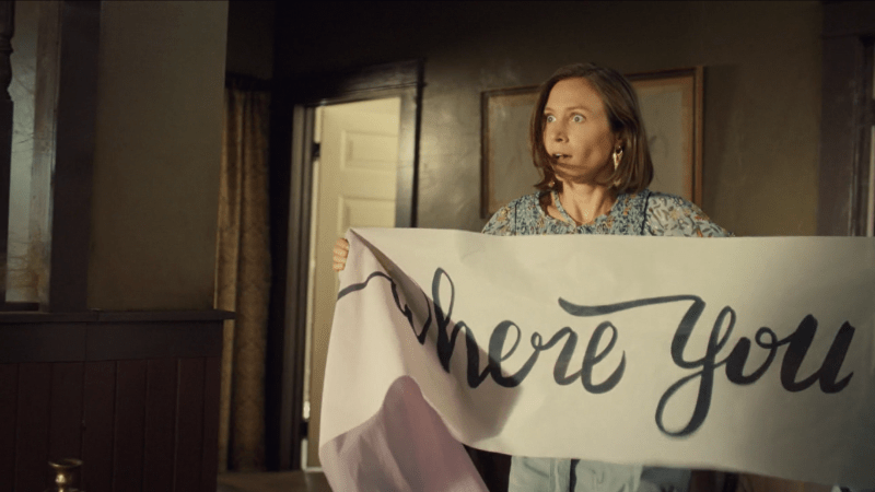 Waverly holds up a banner that almost definitely does not say WHORE but could if you look fast enough because cursive.