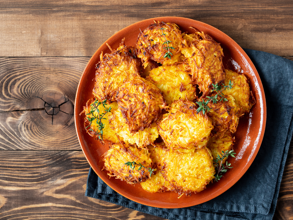 Potatoes pancakes latkes, flapjacks, hash brown or potato vada on brown wooden table.