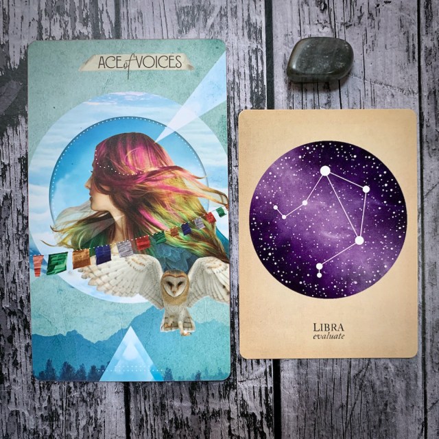 A tarot card for the Ace of Voices, featuring a woman with multicolored hair and a flying snowy owl; a constellation card reading Libra: Evaluate, and a gray crystal