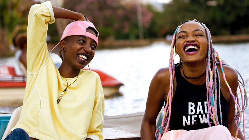 Good First Date Movies for Lesbians: Samantha Mugatsia and Sheila Munyiva in Rafiki share a laugh on a boat