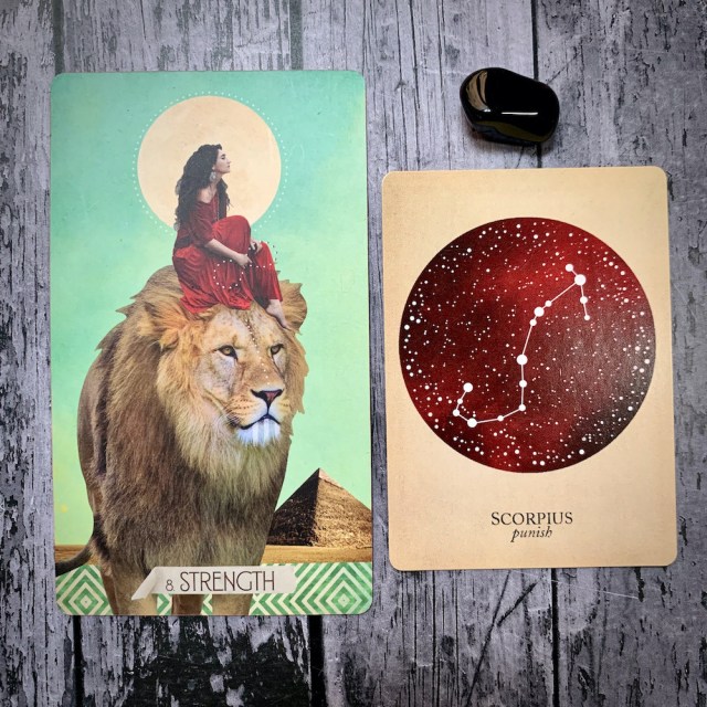 A tarot card for Strength, featuring a white woman in a red dress seated calmly astride a lion; a constellation card reading Scorpius: Punish, and a black crystal