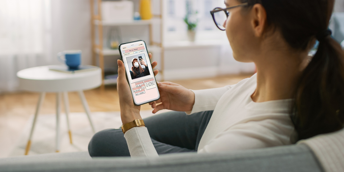 A woman with glasses and a ponytail leans back on a couch, scrolling on a phone displaying the Struck dating app on the screen