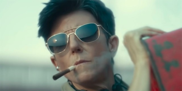 Tig Notaro in aviator sunglasses and a cigar, looking like a stone cold hottie.