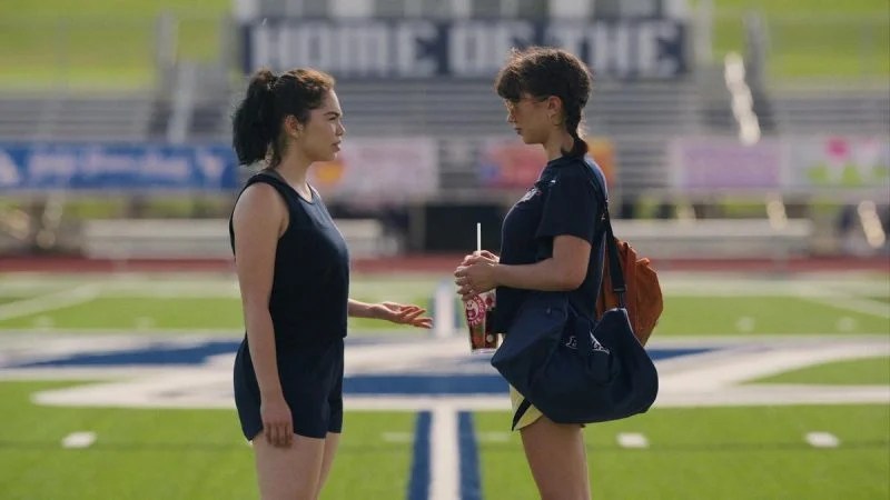 AJ and Paige looking at each other on the track field