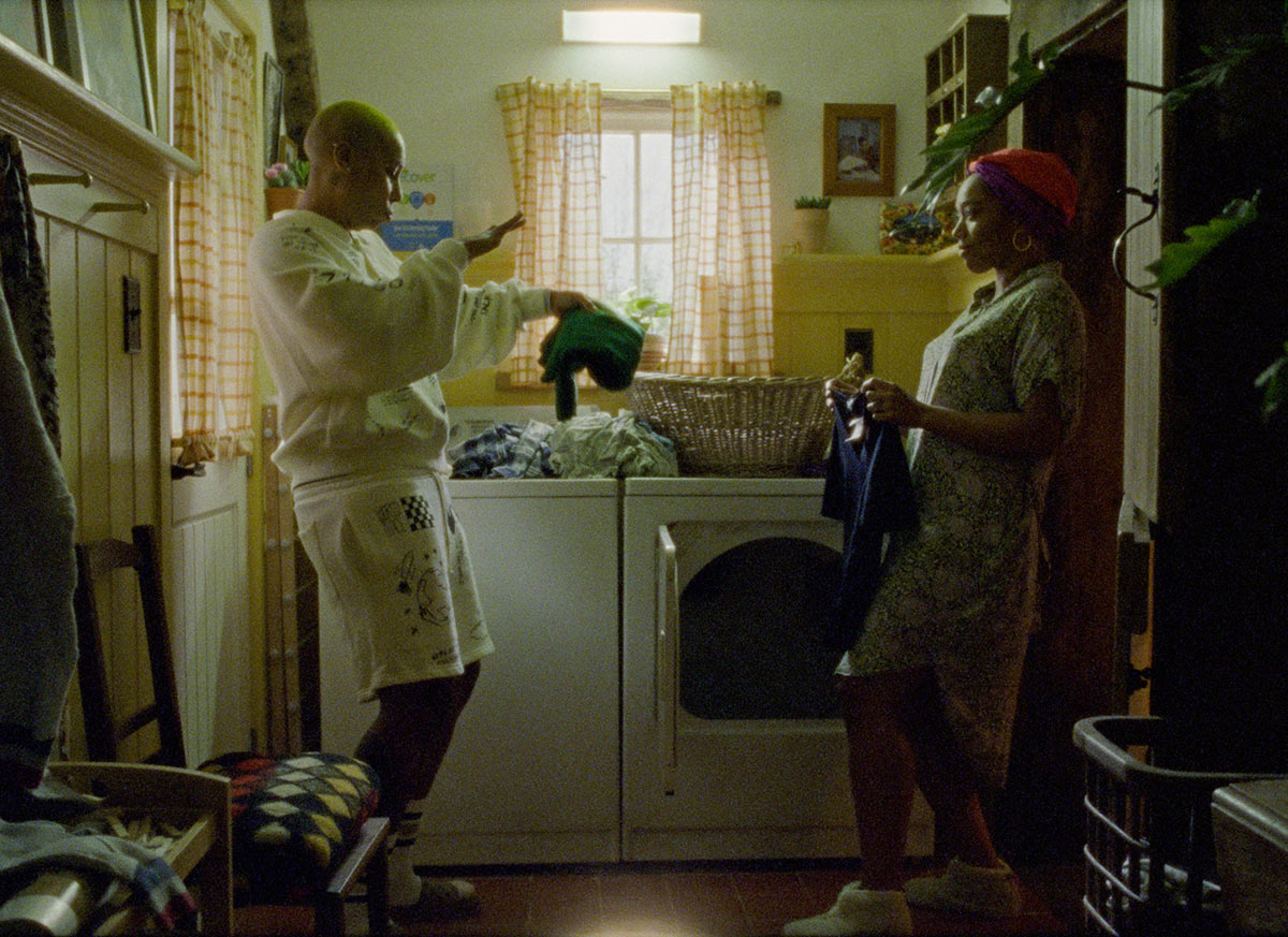 In a still from the third season of Master of None, Lena Waithe's Denise dances while doing laundry with Naomi Ackie's Alicia