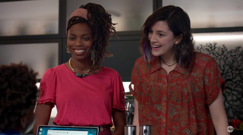 Two wives, one Black and one white, cheer on their sun in the family kitchen.