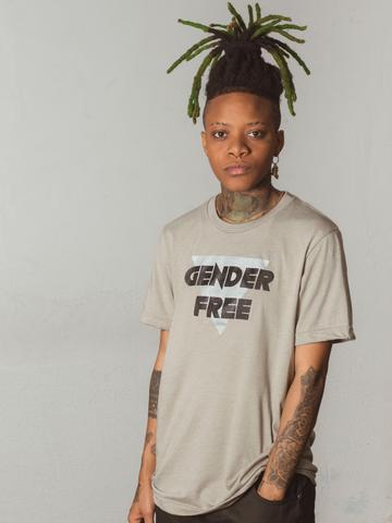 model in a tan t-shirt that reads "GENDER FREE" in brown letters over an upside down light-blue triangle
