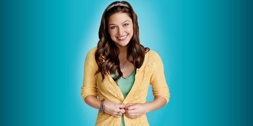 Sweet Marley Rose smiles wearing sunshine yellow against a clear teal background.