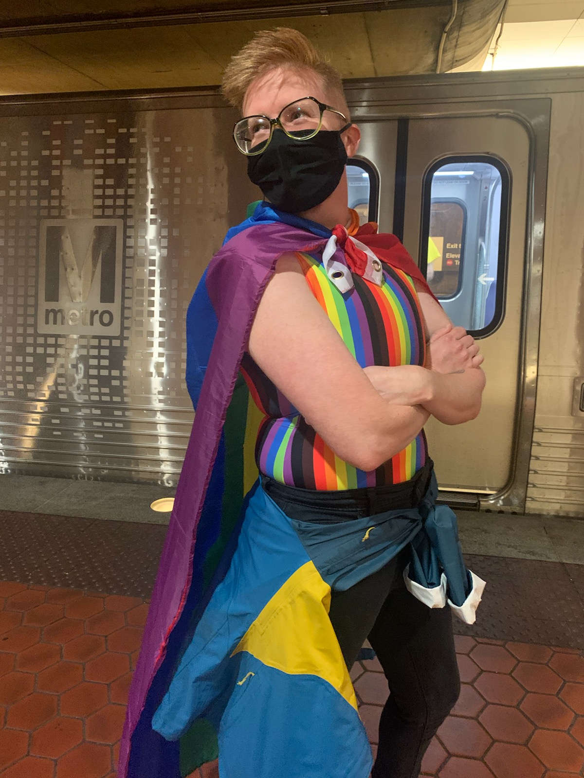 Jo in a rainbow flag cape and mask