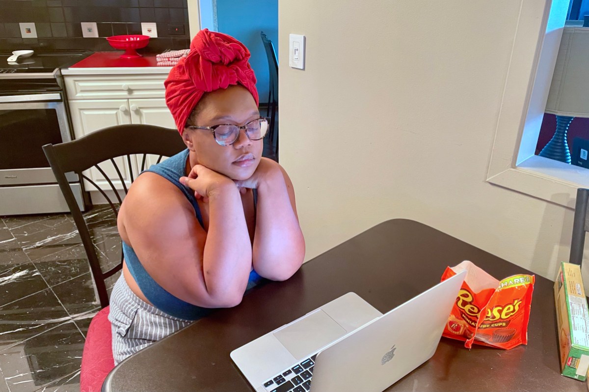 Carmen working at the kitchen table with a pile of Reese's