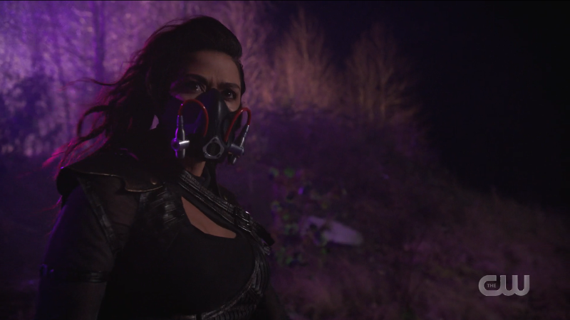 Kayla stands in the purple wasteland with her mask on and it's very attractive.