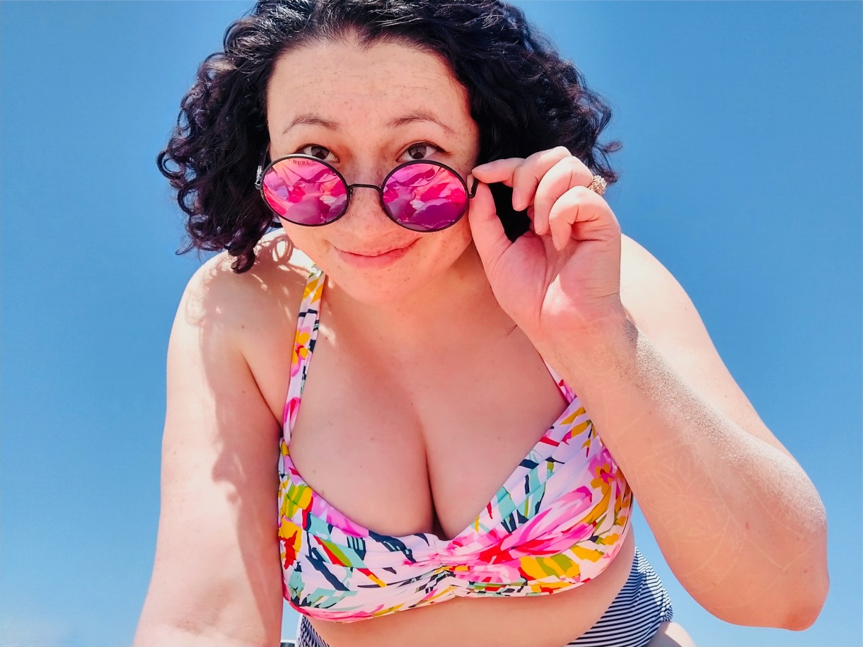Laura in pink sunglasses at the beach