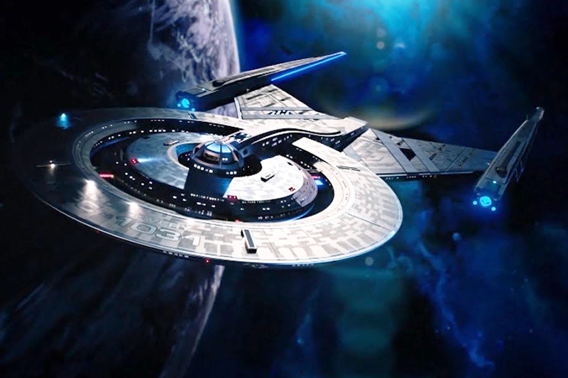 The starship Discovery from Star Trek flaying by a planet against a starry backdrop