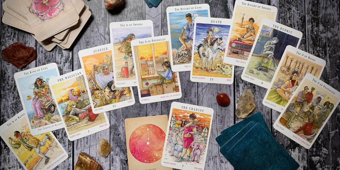 A spread of Next World tarot cards spread over a wooden backdrop