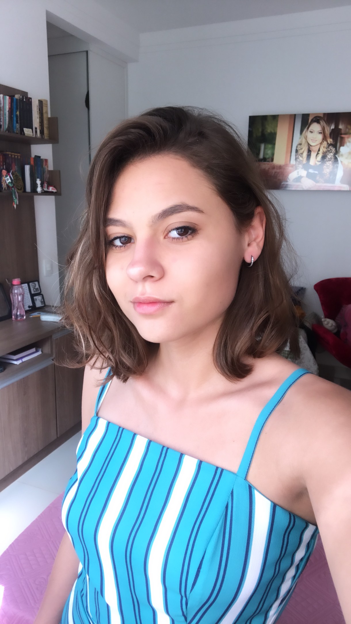 Julia posing for a selfie in a blue striped tank