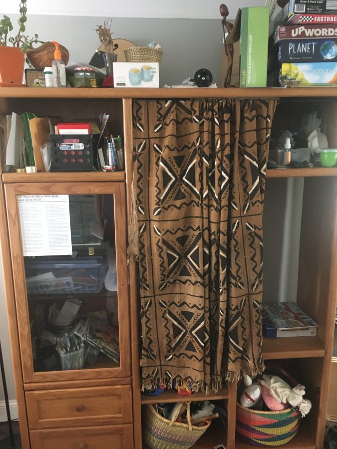 an image of a cabinet with various items stored on it and a curtain used to cover some of the cabinet space