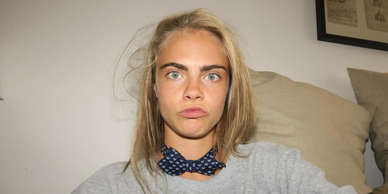 Cara Delevingne in a close up making silly faces with her eyebrows showing prominently