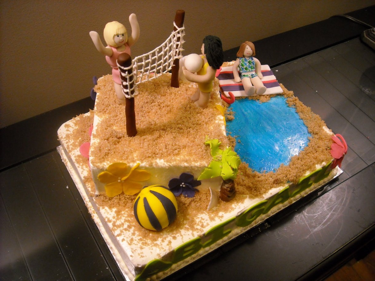 a cake decorated to look like a beach with people playing volleyball