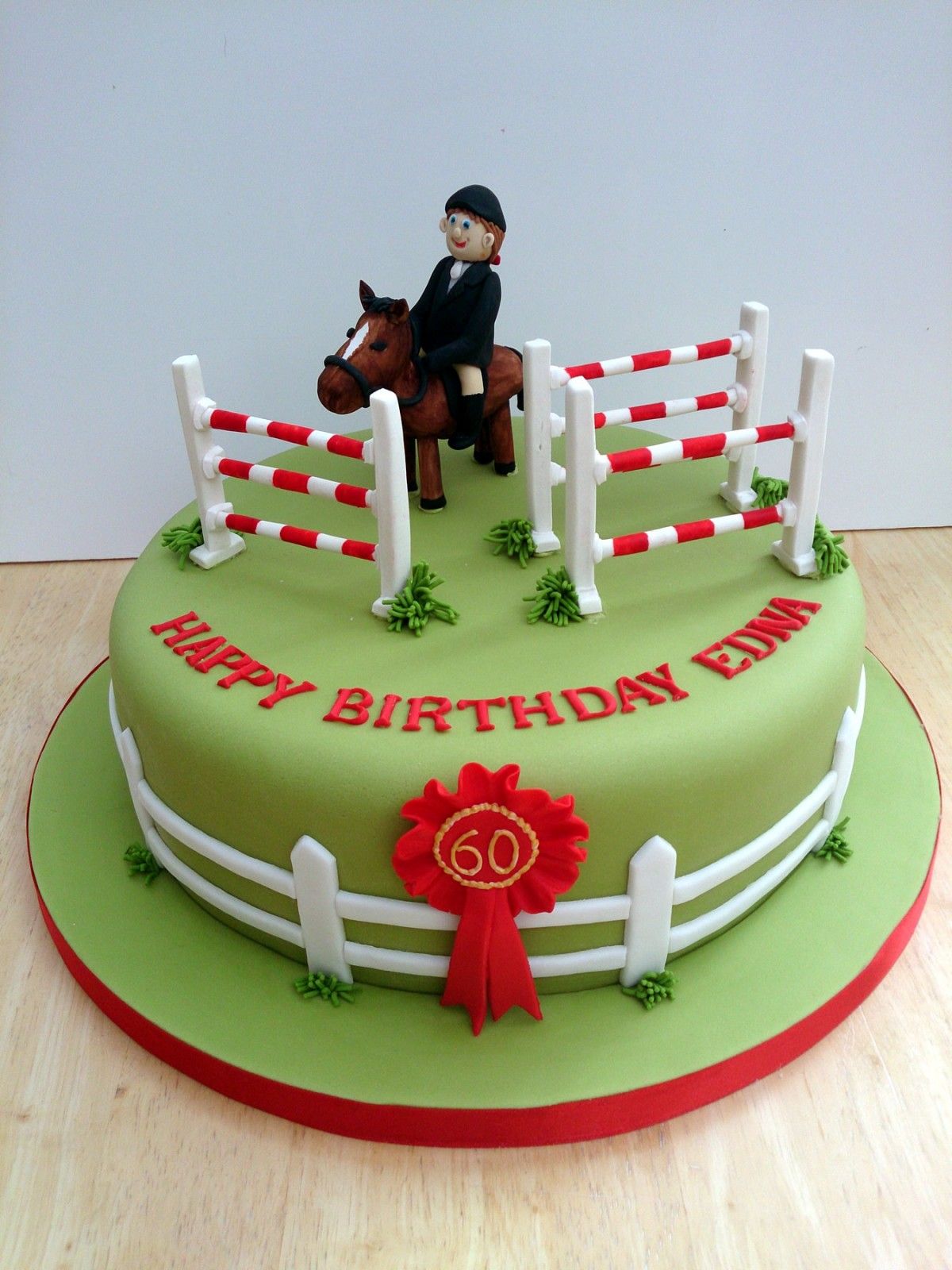 a cake saying happy birthday edna with a woman on a horse and some fences