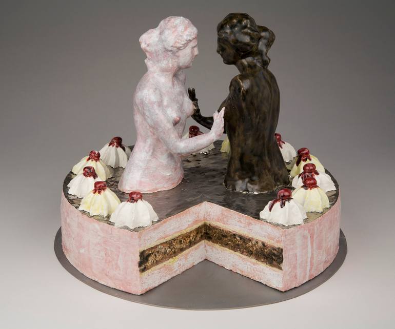 a sculpture of a cake that looks like a sculpture of two women groping each others