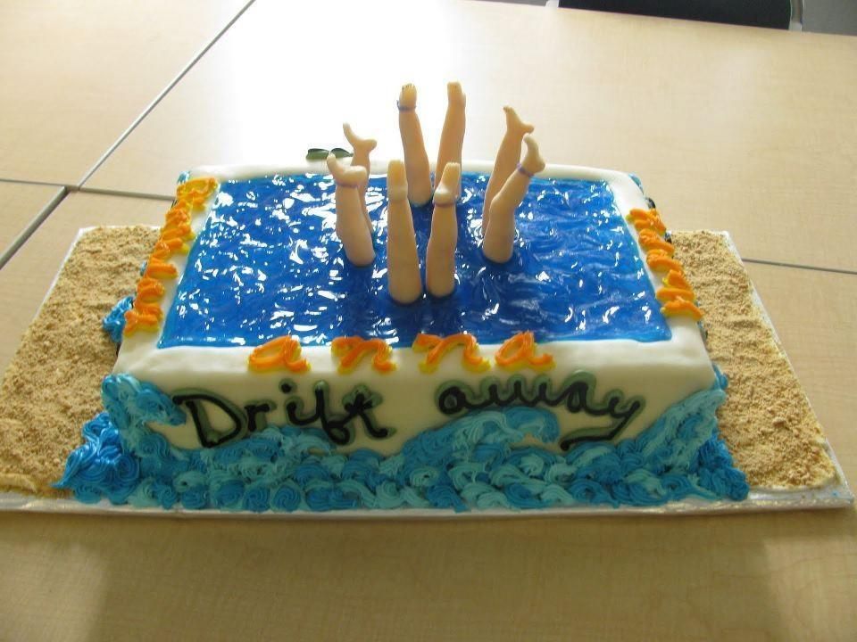 a cake decorated to look like a swimming pool with four sets of legs sticking out
