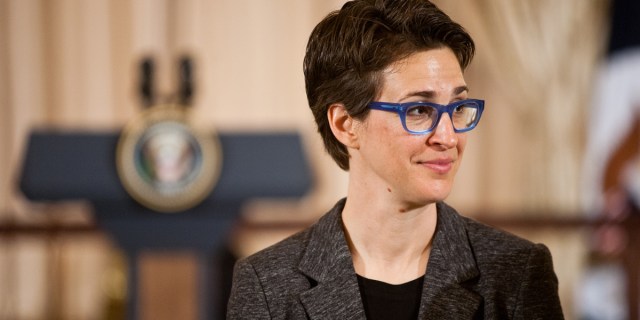 Rachel Maddow, who is considering leaving MSNBC, in a brown blazer and blue glasses at the White House