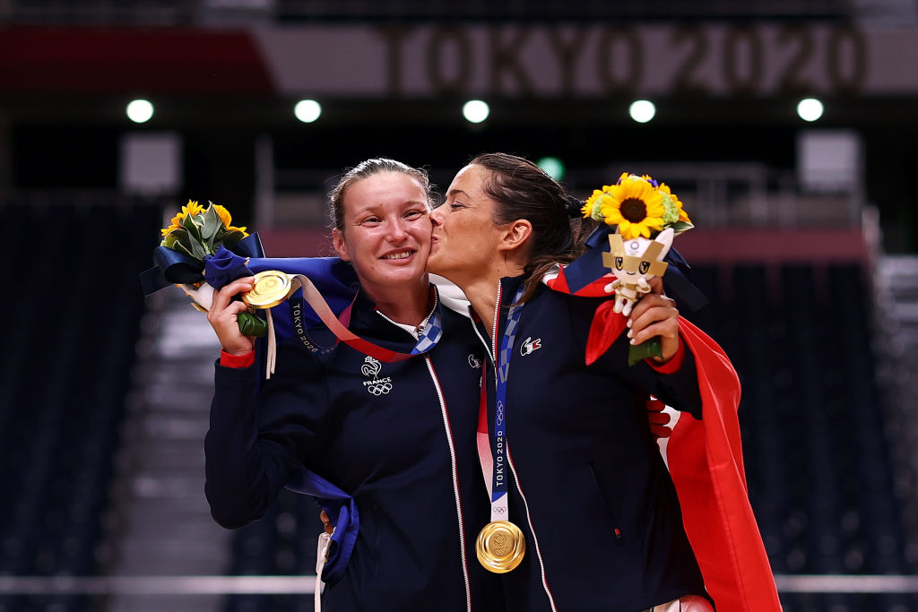 Cleopatre Darleux kisses teammate Amandine Leynaud of Team France while posing with their gold medals during the medal ceremony for Women's Handball on day sixteen of the Tokyo 2020 Olympic Games at Yoyogi National Stadium on August 08, 2021 in Tokyo, Japan. (Photo by Dean Mouhtaropoulos/Getty Images)