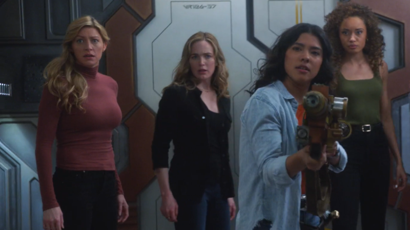 Spooner holds up a laser gun with Ava, Sara and Astra close behind her 