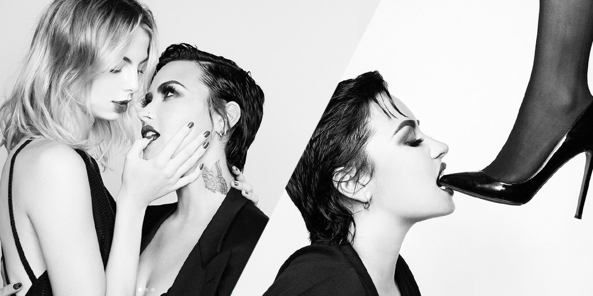 In two black and white images, Demi Lovato has their hair slicked back. In one they are sucking on a blonde woman's finger, in the other they are biting on a high heel
