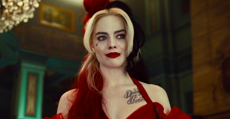 Harley Quinn in 2021 The Suicide Squad quietly cries while facing the camera in a red ball gown