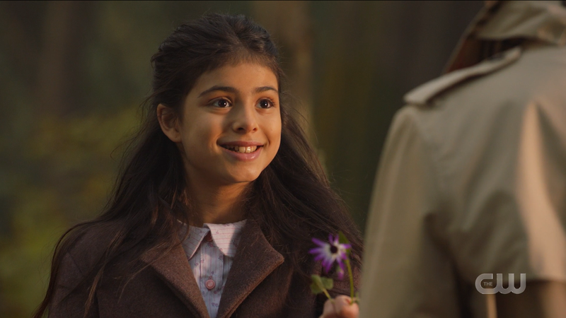Little Esperanza smiles and offers a flower 