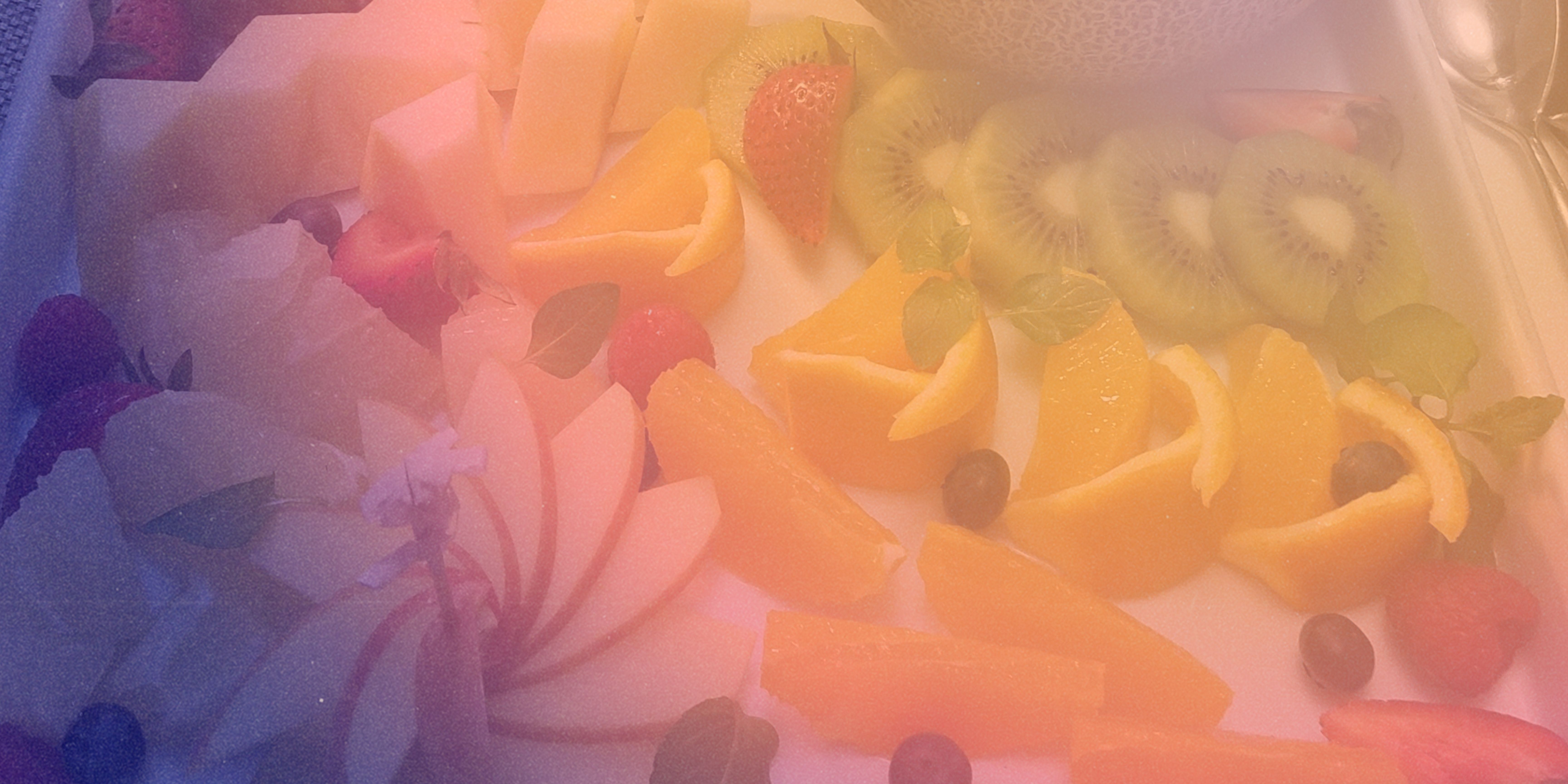 A photo of a fruit platter with a purple to orange gradient on it.