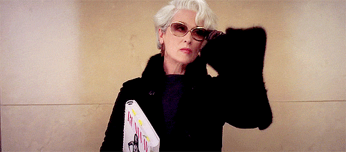 A gif of Miranda Priestly putting on sunglasses with a lot of attitude