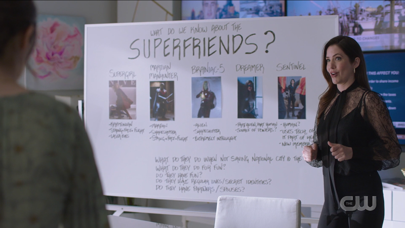 Andrea stands in front of her Superfriends whiteboard