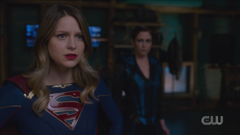 Kara stands with her hands on her hips, determined