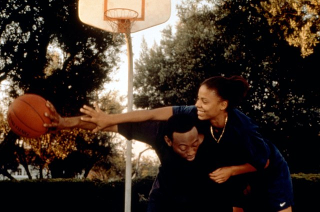 In a still from Love and Basketball, Sanaa Lathan and Omar Epps smile and play basketball.